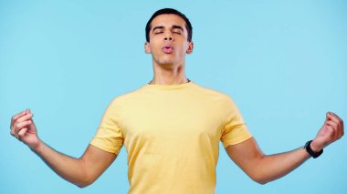 Sarı tişörtlü genç adam, mavi tişörtlü, soluk alırken meditasyon yapıyor.