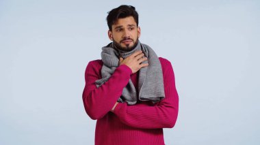 Hırkalı ve atkılı hasta adam mavi üzerine izole edilmiş. 