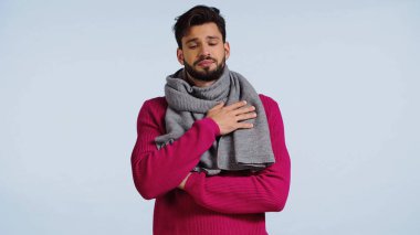 Pembe kazak ve eşarp giyen hastalıklı adam mavi üzerine izole edilmiş. 