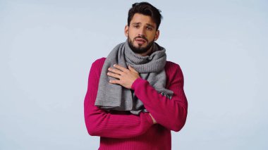 Hüzünlü ve sakallı adam mavi kazak ve eşarplı. 