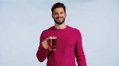 Mavi üzerine izole edilmiş bira bardağını tutan gülümseyen adam. 