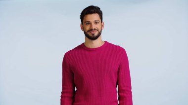 Pembe kazaklı neşeli ve sakallı adam mavi üzerine izole edilmiş. 