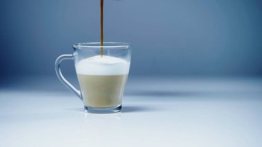 coffee pouring into milk with foam on white and grey  clipart