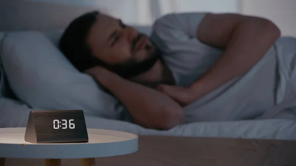Uhr Auf Nachttisch Neben Verschwommenem Mann Bett — Stockfoto