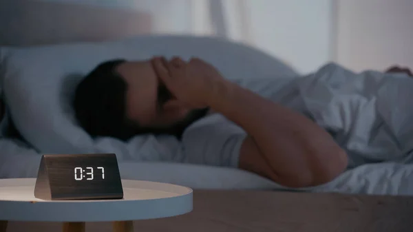 Clock Bedside Table Blurred Man Covering Face Bed Night — Stockfoto
