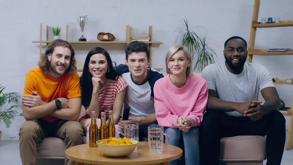 Amigos Multiétnicos Felices Sentados Sofá Cerca Cerveza Las Papas Fritas — Foto de Stock