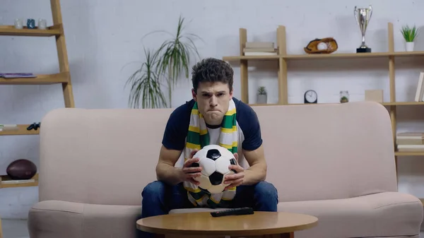 Nervous Sport Fan Striped Scarf Holding Ball While Watching Football — Stock Photo, Image