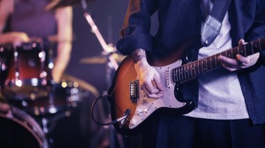 KYIV, UKRAINE - DECEMBER 30, 2021: cropped view of tattooed guitarist playing on stage 