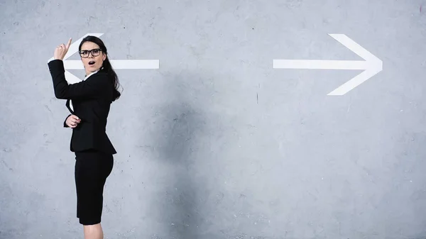 Sorprendida Empresaria Gafas Teniendo Idea Cerca Flechas Sobre Gris — Foto de Stock