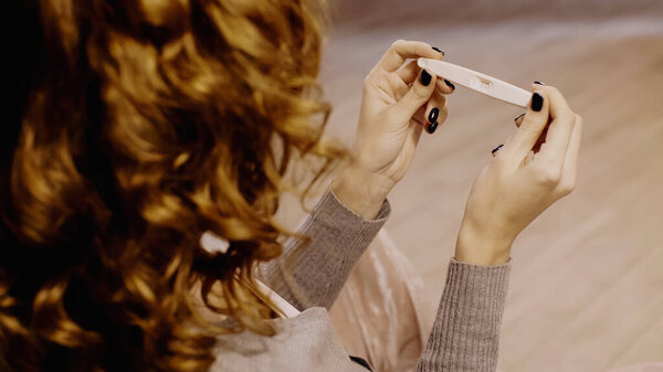 Overhead view of woman holding pregnancy test 