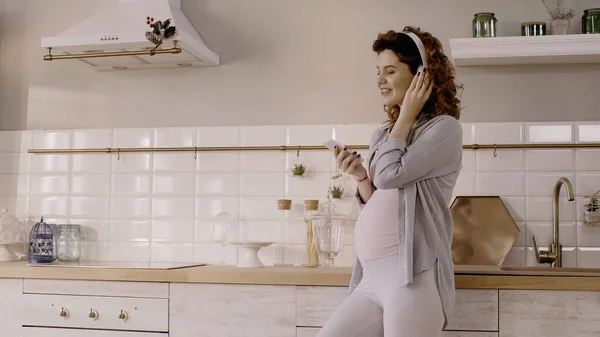 Mujer Embarazada Alegre Usando Auriculares Teléfono Celular Cocina — Foto de Stock