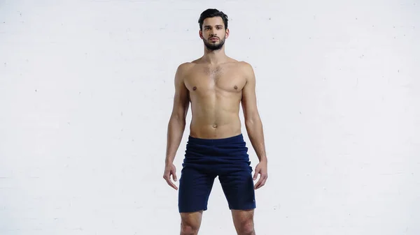 Deportista Sin Camisa Pantalones Cortos Pie Cerca Pared Ladrillo Blanco —  Fotos de Stock