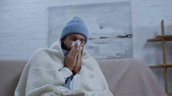 Sick Man Warm Beanie Blanket Sneezing Paper Napkin While Sitting — Stockfoto