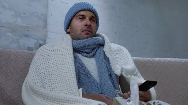 Diseased Man Warm Hat Scarf Blanket Watching Couch Home — Zdjęcie stockowe