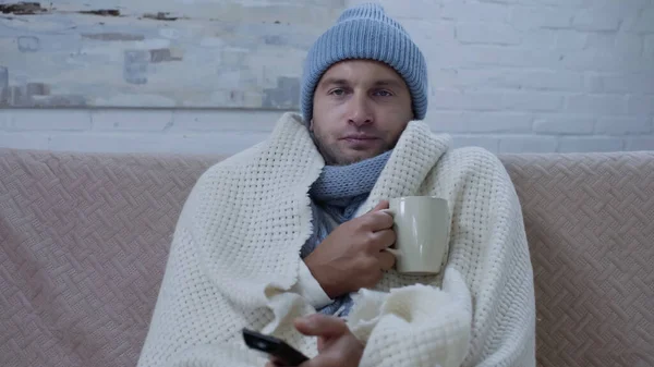 Sick Man Warm Blanket Hat Sitting Couch Cup Tea Watching — Stockfoto