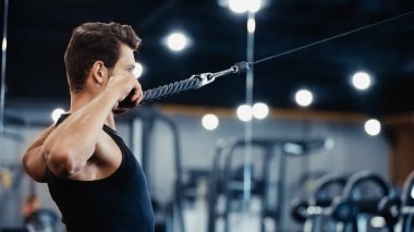 side view of young sportsman exercising in gym