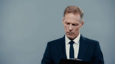 Businessman in formal wear holding clipboard isolated on grey 