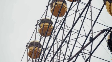 low angle view of ferris wheel in chernobyl amusement park against grey sky