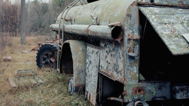 damaged and rusty military vehicle in forest in chernobyl exclusion zone