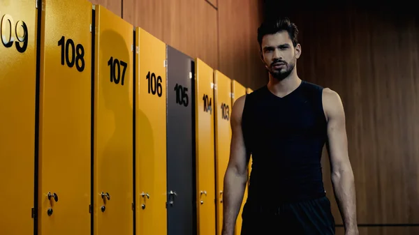 bearded sportsman looking at camera in locker room