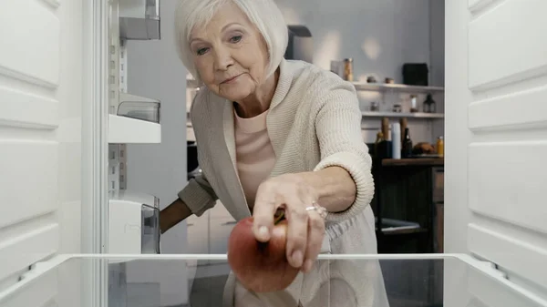 Senior Woman Taking Ripe Red Apple Fridge Kitchen — Stock Fotó