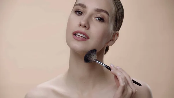 Young Woman Applying Face Powder Cosmetic Brush Isolated Beige — Stockfoto