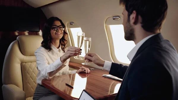 在私人飞机上笑着喝香槟的情侣 — 图库照片