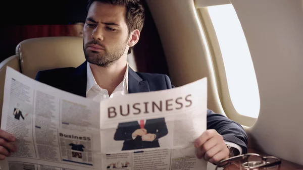 Businessman Reading Newspaper Eyeglasses Private Plane — стоковое фото