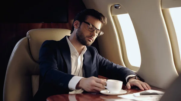 Businessman Taking Cup Coffee Cellphone Private Plane — Stock fotografie