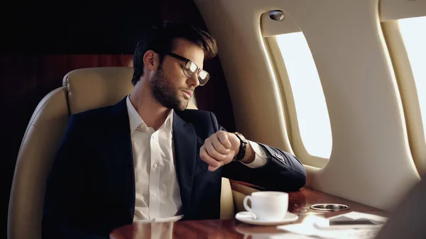 Businessman Looking Wristwatch Coffee Cellphone Private Plane — Zdjęcie stockowe