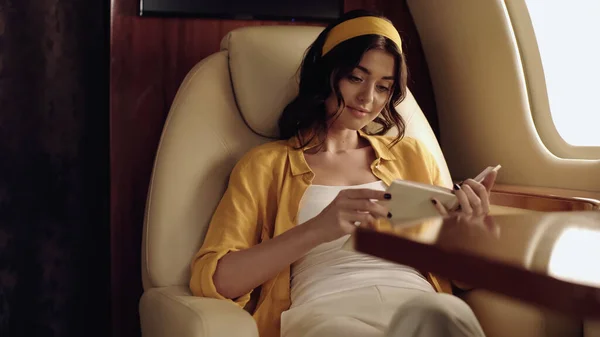 Young smiling woman reading book in private jet
