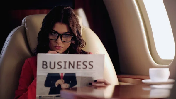 Focused Businesswoman Reading Newspaper Private Plane — стоковое фото