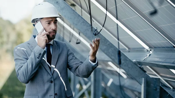 Displeased Businessman Looking Hanging Wire While Talking Smartphone Solar Panels — стоковое фото