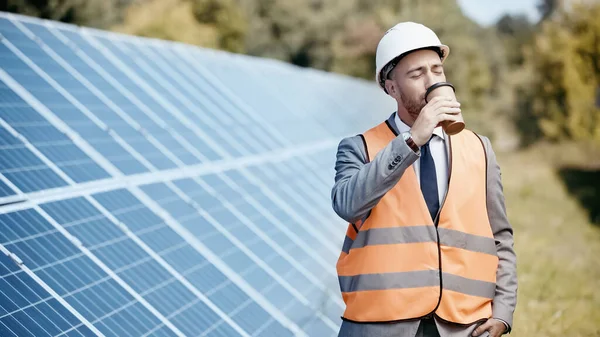 Επιχειρηματίας Hardhat Πίνοντας Καφέ Για Πάει Κοντά Ηλιακές Μπαταρίες Έξω — Φωτογραφία Αρχείου