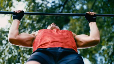Kaslı sporcunun yatay çubukta barfiks çekerken alttaki görüntüsü