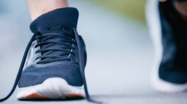 Mavi spor ayakkabılı sporcunun kırpık manzarası