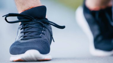 Mavi spor ayakkabılı sporcunun kırpık manzarası
