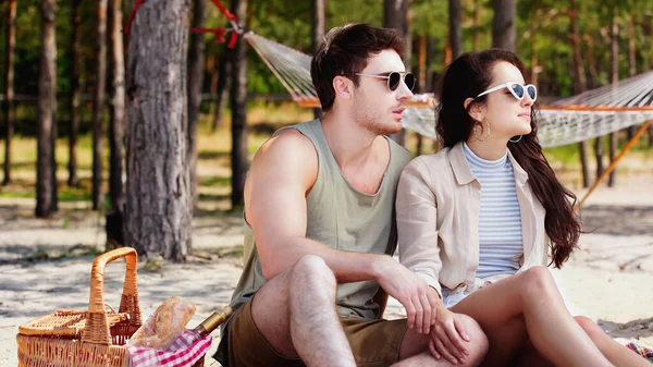 Pareja Joven Gafas Sol Sentada Cerca Cesta Picnic Playa — Foto de Stock