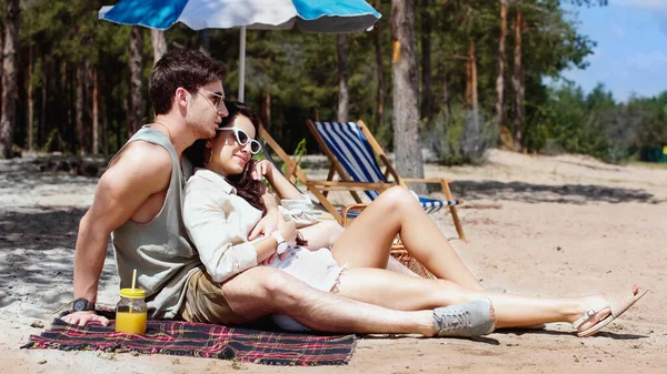 Uomo Abbracciare Donna Occhiali Sole Vicino Succo Arancia Sulla Spiaggia — Foto Stock