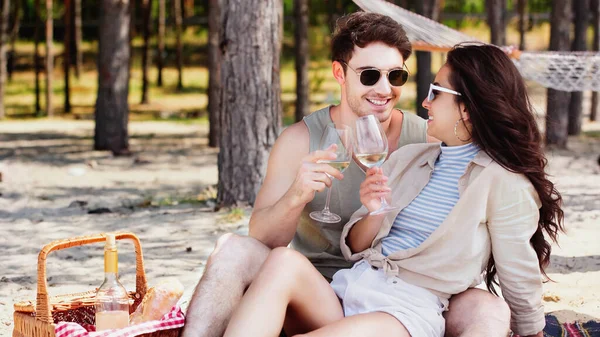 笑顔男保持ワイン近く恋人でサングラスでピクニック中にビーチ — ストック写真