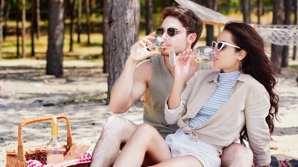 Brunette Couple Sunglasses Drinking Wine Picnic Basket Beach — Stock Photo, Image