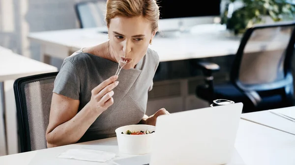 Bizneswoman Jedzenie Sałatki Pobliżu Kawy Aby Przejść Zamazany Laptop Biurze — Zdjęcie stockowe