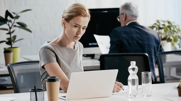 Geschäftsfrau Offizieller Kleidung Schreibt Auf Papier Der Nähe Von Laptop — Stockfoto