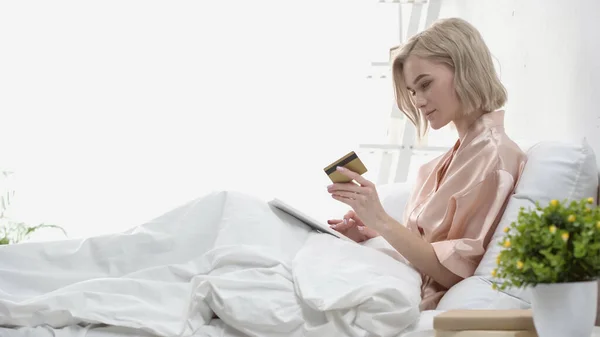 Вид Збоку Білявка Жінка Тримає Цифровий Планшет Кредитну Картку Ліжку — стокове фото