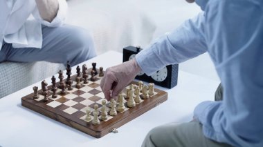 cropped view of senior chess players gaming at home
