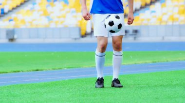 cropped view of sportive football player bouncing soccer ball with legs