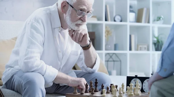 Senior Bearded Man Thinking Chessboard Blurred Friend — 图库照片