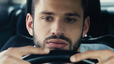 tired man with sweaty forehead driving car while suffering from heat