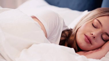 Young woman sleeping on bed in morning 