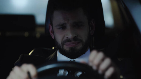 depressed and frustrated businessman driving auto in evening